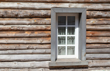 Window with a wooden wall from a log house.