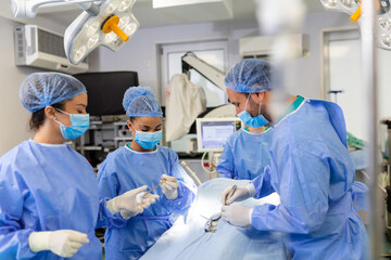 Surgery operation. Group of surgeons in operating room with surgery equipment. Medical background, selective focus. Surgeon team working together while operation