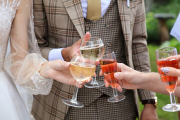 The bride and groom drink champagne at the wedding.