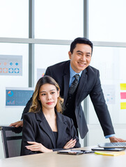 Asian cheerful female businesswoman secretary posing smiling together in company office meeting room.