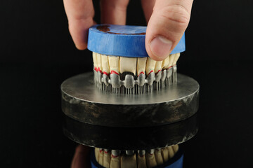 Dental technician checks his work in the lab