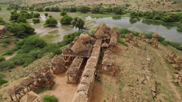 Incredible 4K aerial footage without people of Bada Bagh sandstone cenotaphs next to a river. Day time