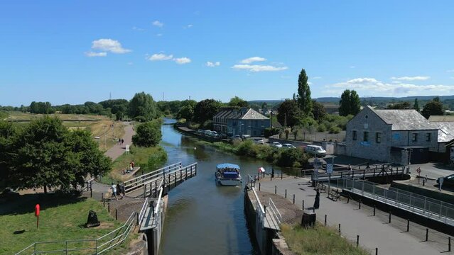 A boat passing through the River Exe swing bridge and onto Exeter Canal, Devon. Drone Video. 30fps. 