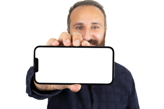 Showing Horizontal Smartphone, Selective Focus Of Caucasian Male Showing Horizontal Smartphone. Isolated On White Background. Modern Mobile Phone Mock Up. Recommendation Online Game, App Concept Idea.