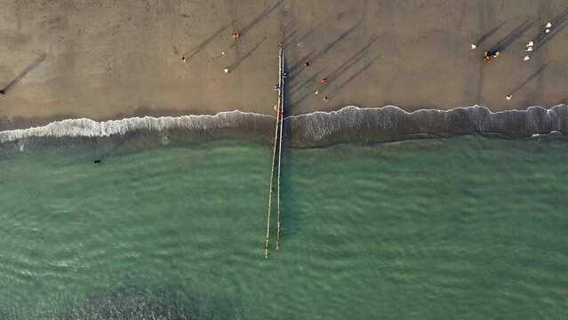Aerial view of the vacationers and fishermen on Cox's Bazar Sea Beach on a sunny day, Bangladesh