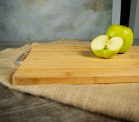 Green apple on wooden cutting board