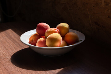 Harvest of ripe apricots in a plate. Apricots. Summer background.
