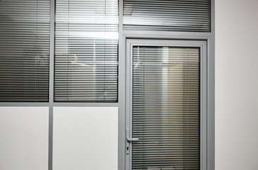 Wall and glass door with roller blind. Modern office interior, closeup