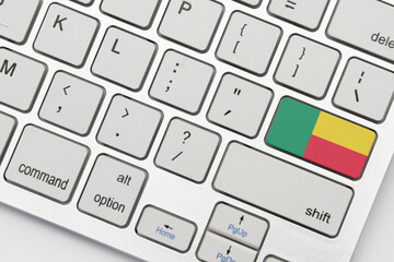national flag of benin on the keyboard on a grey background .3d illustration