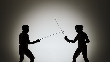 Side view of black silhouettes two young female swordswoman with crossed rapiers. Athletes in white...