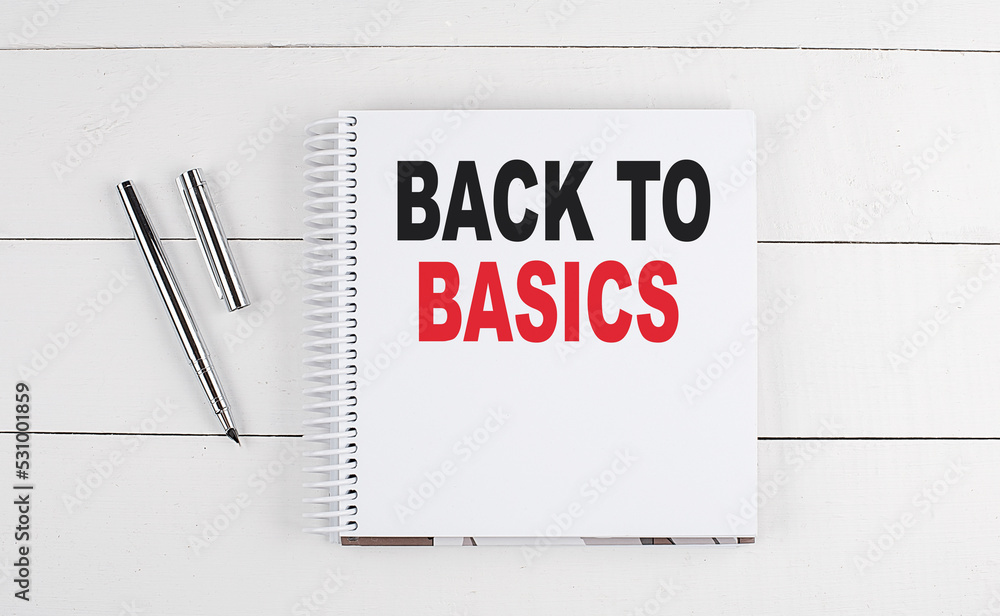 Poster back to basics text written on notebook on the wooden background