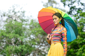 portrait pretty woman transgender standing and raise an umbrella among nature atmosphere
