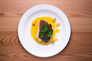 Bacalao al pil pil traditional tapa from the north of Spain. Coconut fish cooked with a delicious sauce made with oil, cod and garlic.