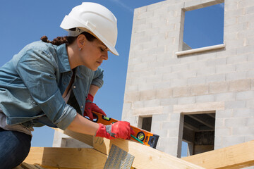 woman works on the carpenter of a house under construction