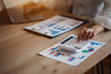 Close-up shot of a business woman working on a calculator and laptop. investment concept.