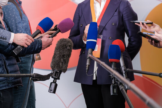 Crop journalists interviewing businessman for television