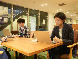 シェアオフィスで仕事をするアジア人男性
