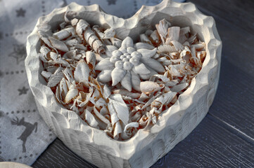 Heart-shaped bowl containing Swiss pine shavings - obrazy, fototapety, plakaty