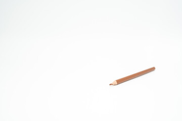 brown wooden colored pencil on a white background with a point (lead) in focus