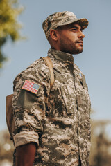 Patriotic young soldier standing at attention outside his home