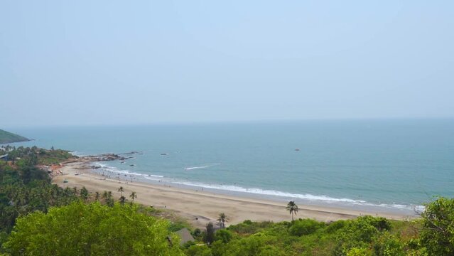 Wide angle shot of Vagator beach as seen from the top of the Chapora Fort at Goa in India. Wide angle shot of beach as seen from above. Blue sea in goa. Summer relaxation background. 