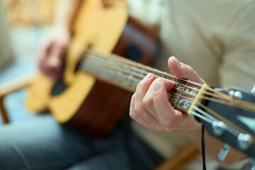 Musician play acoustic guitar, guitarist's hand on fingerboard, closeup. Guitar player perform...