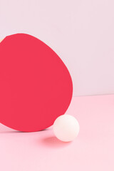 Tennis racket and white ball on a pink pastel background. Creative minimal composition.
