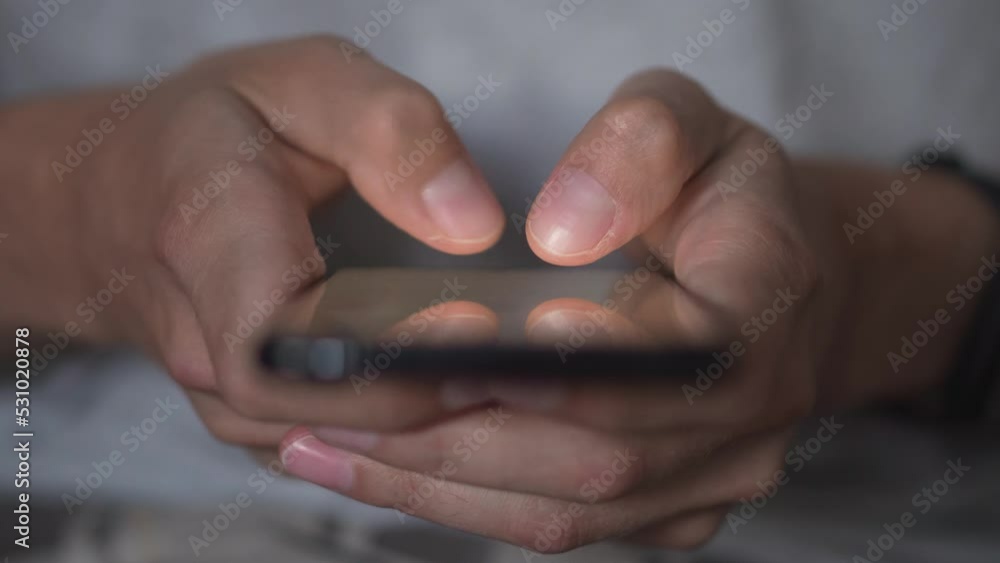 Poster life in a smartphone. a young man looks at a mobile phone and browses social networks, close-up. rel