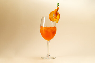 glass of aperol spritz cocktail on brown background.