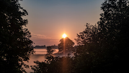 Fototapeta Wschód słońca w wiejskim obszarze zachodniej Polski, w porze wiosennej, okolica spowita mgłami, złote barwy obraz