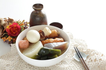 Homemade Japanese winer comfort food, oden fish cake and radish simmered, served with Japanese wine Hot saki