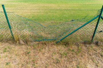 Broken metal chain fence.