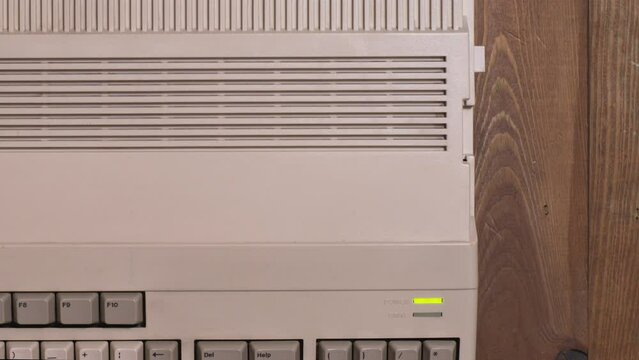 Top view of a hand inserting a floppy into a microcomputer and loading disk