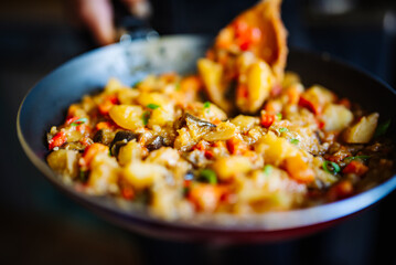 Woman cooking tasty vegetable stew in pan on kitchen