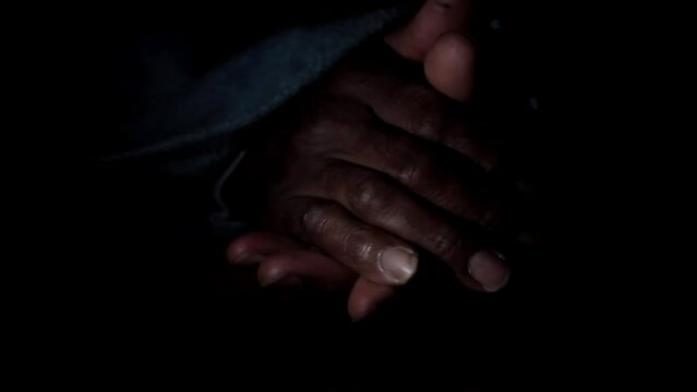 man praying to god with hands together Caribbean man praying with black background stock footage
