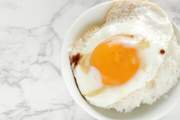 Sunny side up fried egg on rice with soy sauce for Asian breakfast food