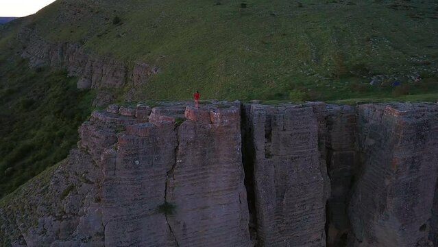 Person Standing On The Edge Of Rock Formation Stolo Of Ponor Mountains In Bulgaria. Aerial Drone Shot