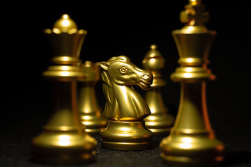 Golden knight chess piece close-up on black background
