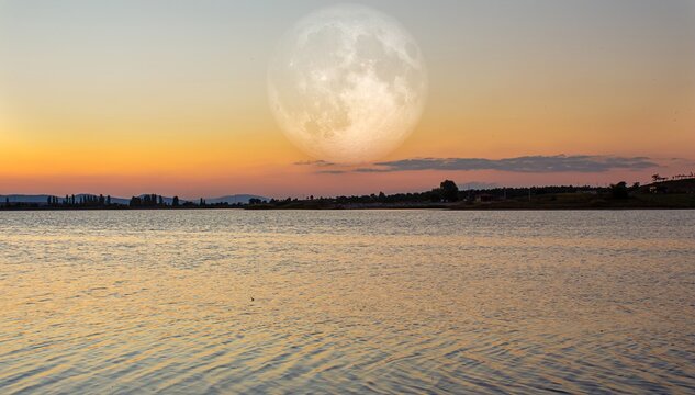 Full moon over the lake view at the sunset. Elements of this image furnished by NASA.