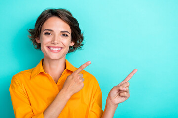 Portrait of cute nice positive girl bob hairstyle wear yellow blouse indicating empty space offer isolated on turquoise color background - obrazy, fototapety, plakaty
