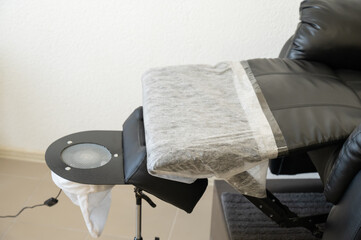Black pedicure chair with dust vacuum cleaner in beauty salon. 
