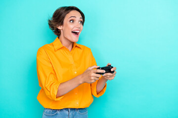 Portrait photo of young adorable pretty cute woman open mouth wear orange shirt surprised gamer excited isolated on cyan color background