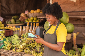Obraz premium african lady in a market using a pos device