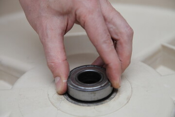 Fototapeta na wymiar Washer machine drum new bearing installation when replacement. Front load washing machine repair
