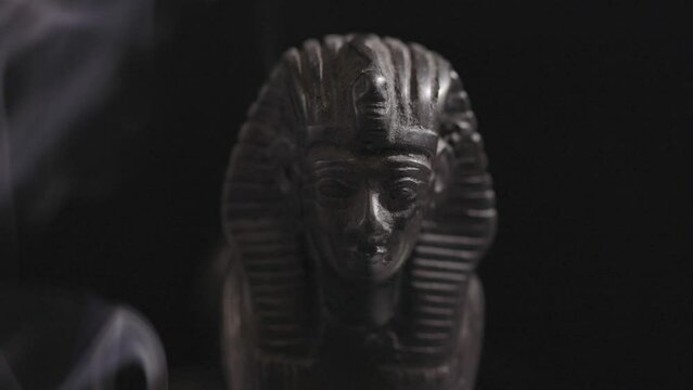 stone statue of the Egyptian sphinx in smoke on a black background