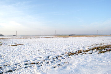 Winter view of the field. Snow on the grass. Countryside in Poland