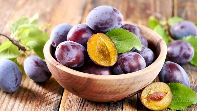 bowl of purple plum and leaf