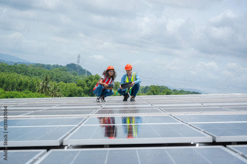 Poster engineers checking the operation of the system solar cell on roof at factory,alternative energy to c