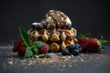 chocolate and ice cream melting over a hot Belgian waffle with berries and flaked chocolate