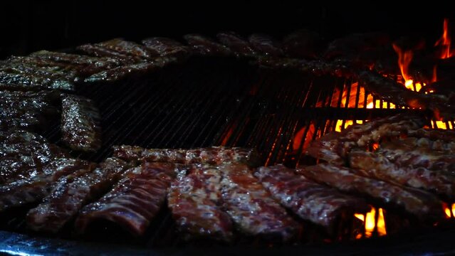 Pork ribs roast on fire, barbecue. Slow motion.